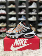 grey, black, and orange Nike Air Max Tailwind IV sneakers resting on a red Nike shoebox