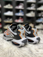 grey, black, and orange Nike Air Max Tailwind IV sneakers resting on a red Nike shoebox