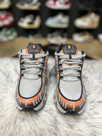 grey, black, and orange Nike Air Max Tailwind IV sneakers resting on a red Nike shoebox